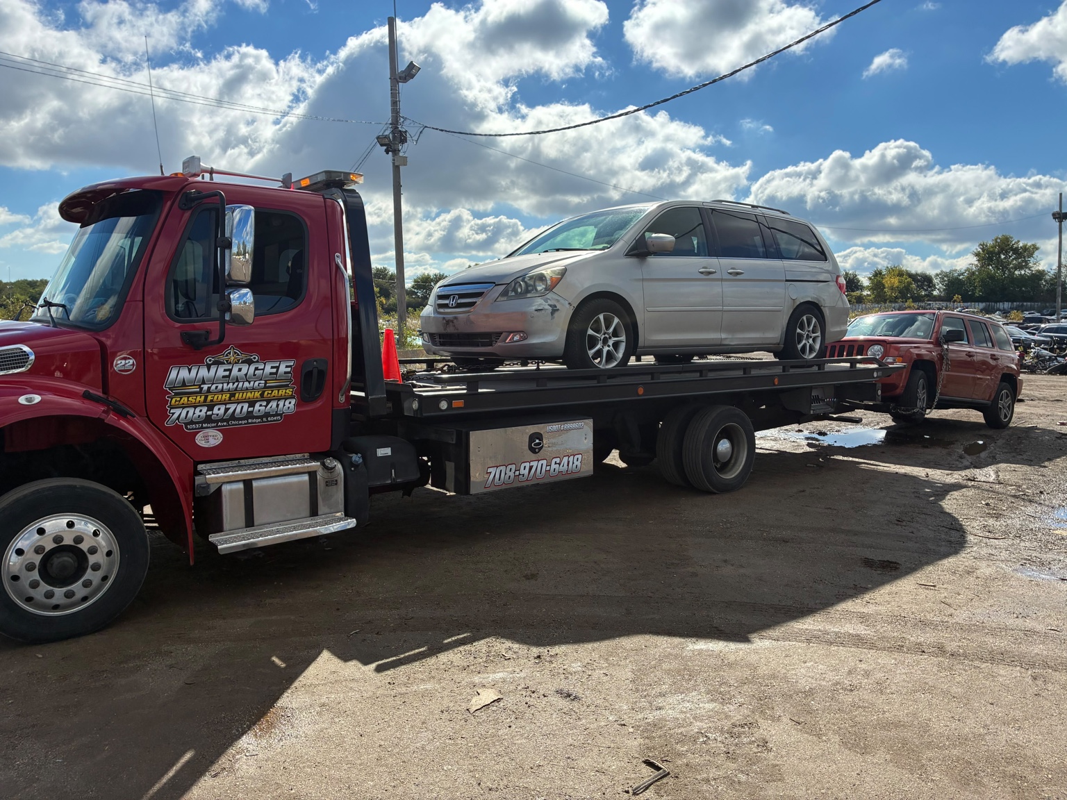Honda minivan on the flatbed with a Jeep behind